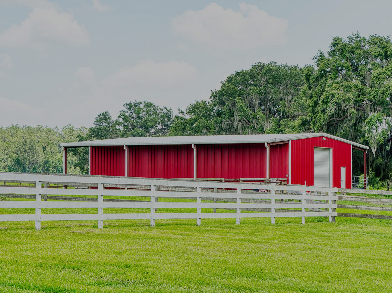 Red barn pavilion and fenced pasture area used for event support and flexible outdoor functions at Covington Farm.